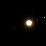 Photograph of Jupiter and its Moons through binoculars.