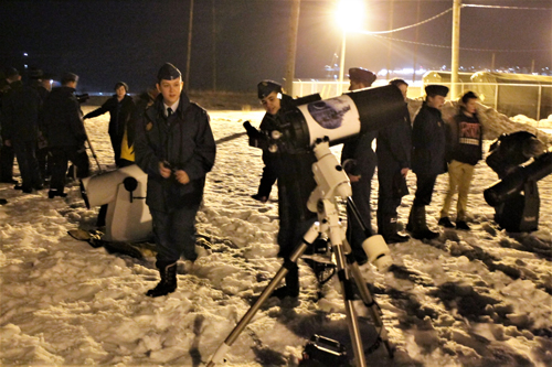 Photo of a group lined up a two telescopes.